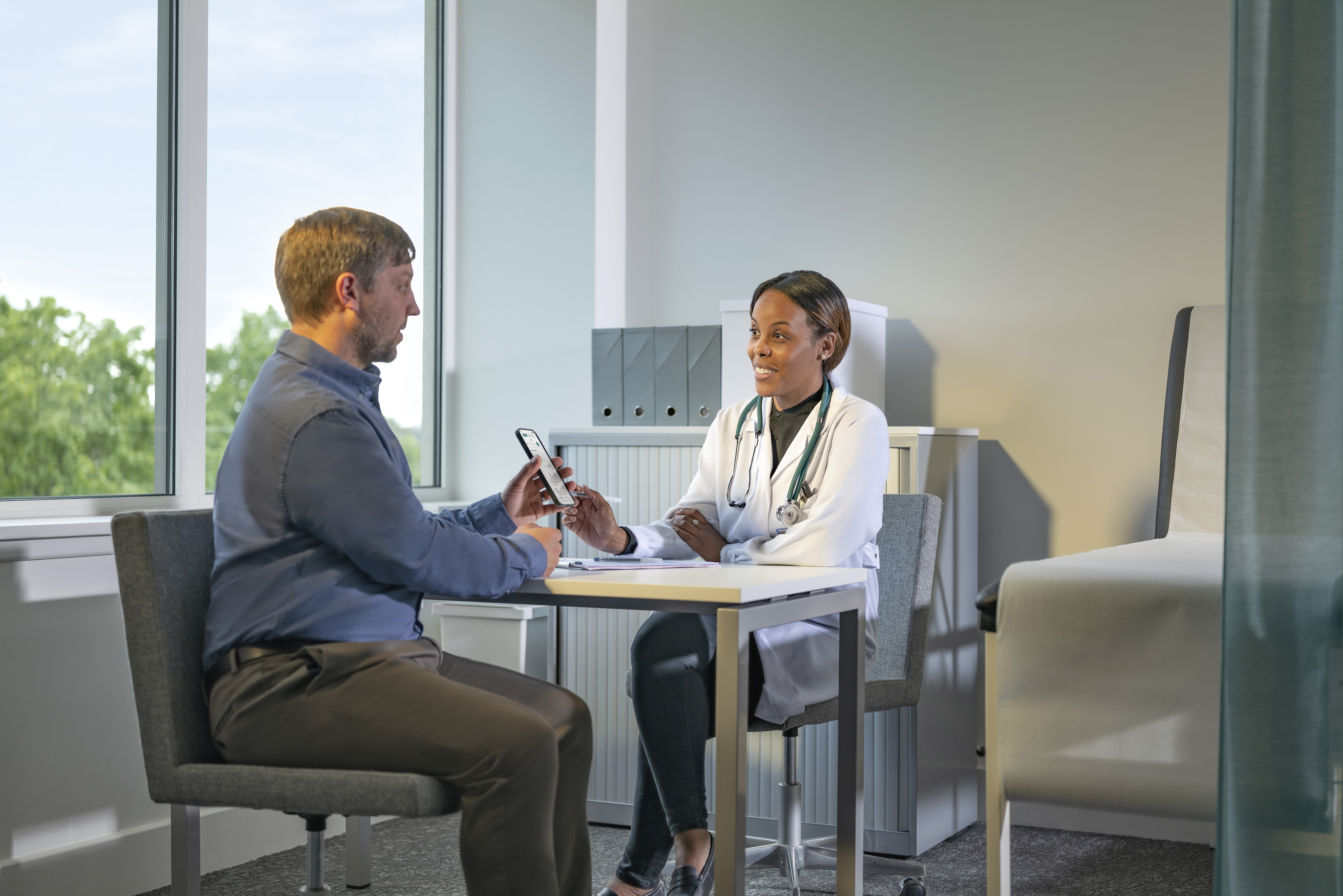 A healthcare provider examines a desktop screen showing patient data