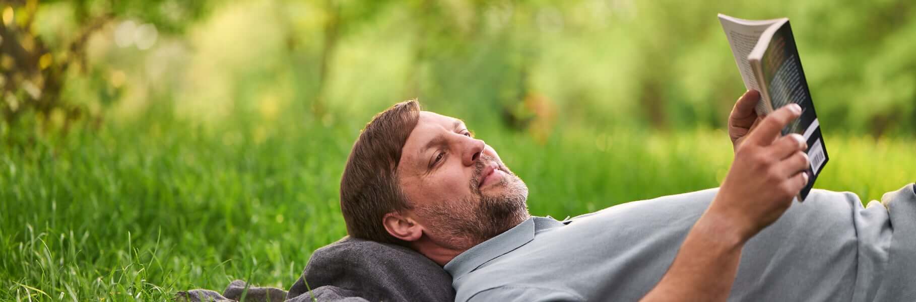 Patient relaxing in a park reading a book