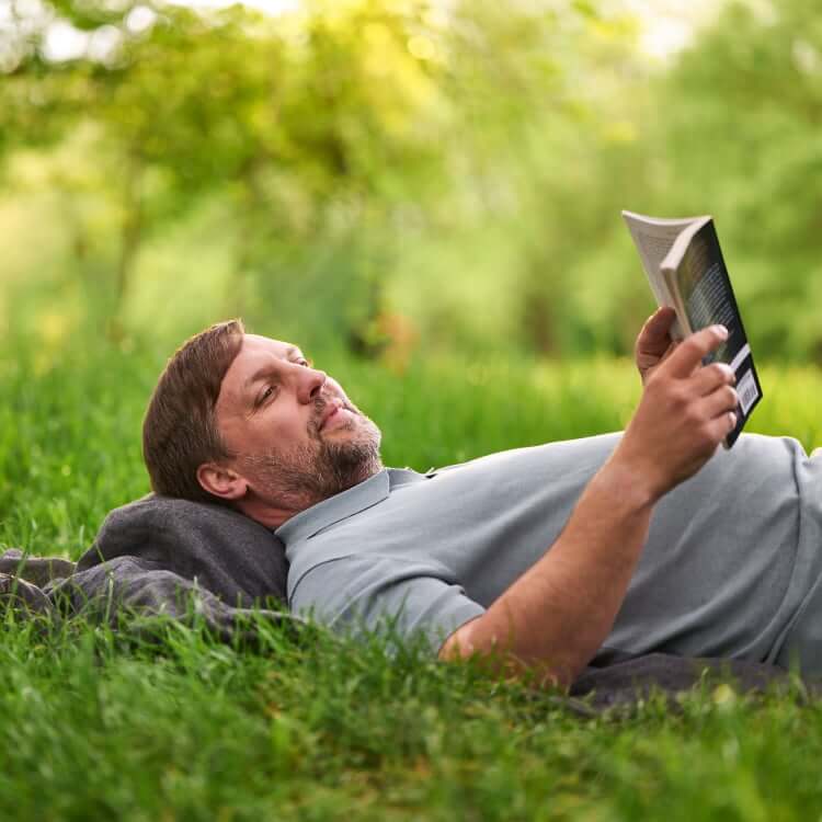 Patient relaxing in a park reading a book