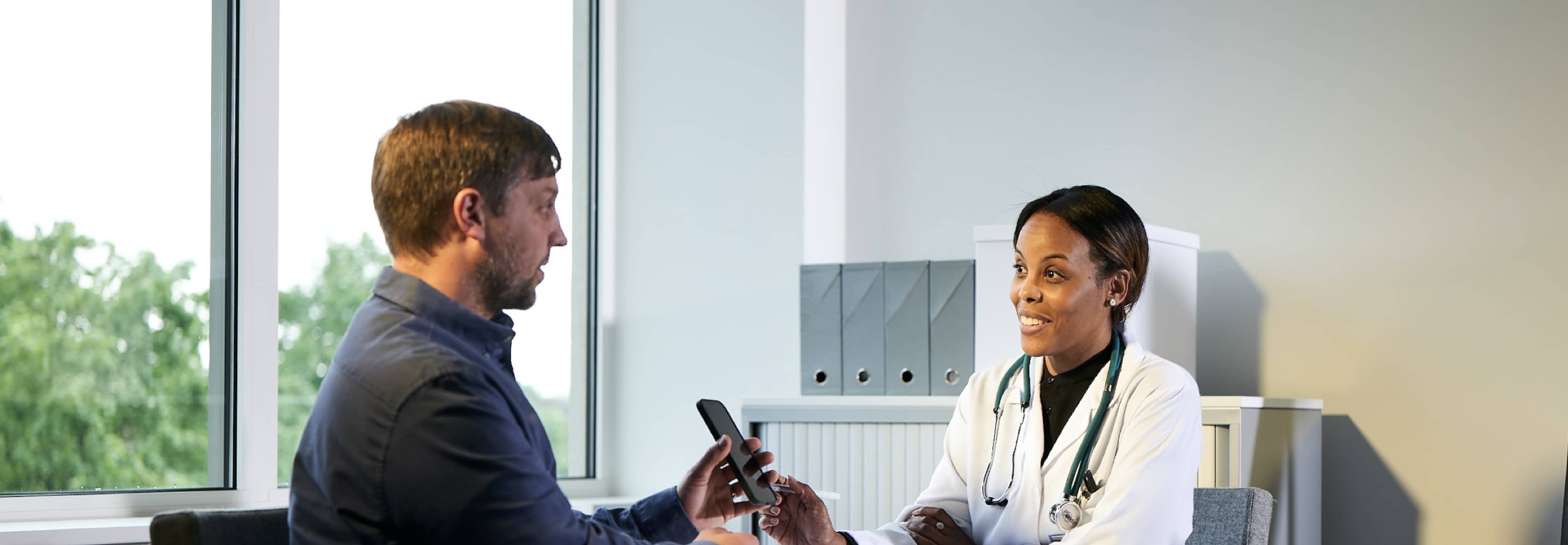 A male patient is in conversation with a female healthcare professional.