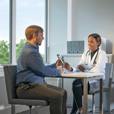 Doctor studying results with patient on his smart phone