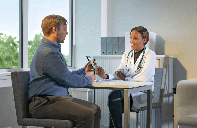 Doctor studying results with patient on his smart phone