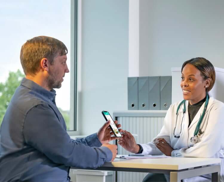 A patient reviews the TempoSmart app with his doctor during an appointment