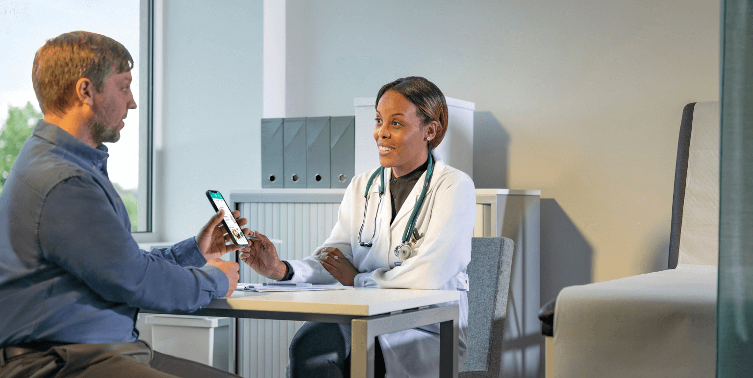 A patient reviews the TempoSmart app with his doctor during an appointment